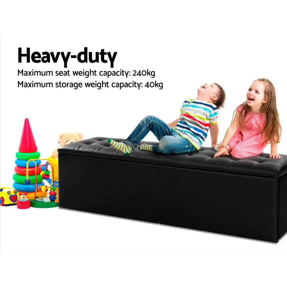 Two kids sitting on a Black Storage Ottoman